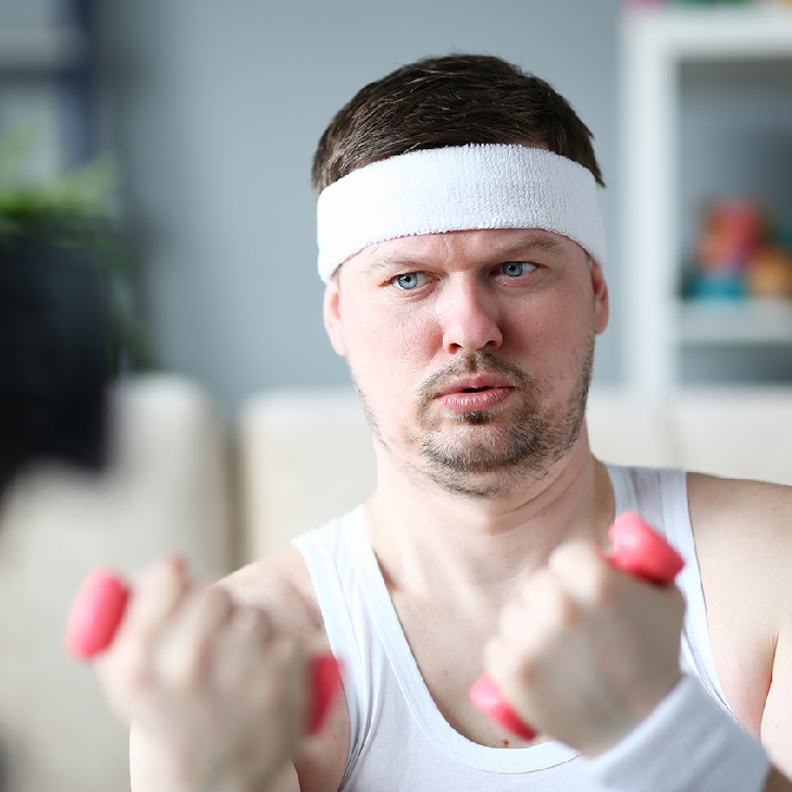 Harry Smith wearing his headband lifting comically small pink weights